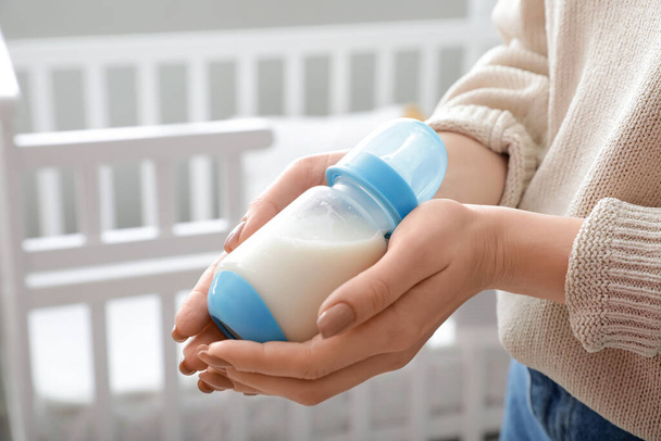 Woman with bottle of milk for baby, closeup - 写真・画像