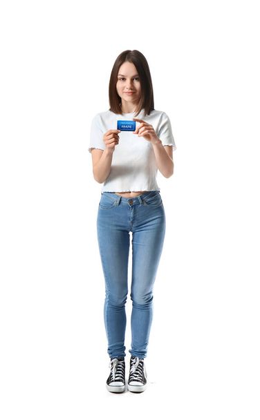 Young woman with covid-19 vaccination card on white background - Foto, imagen