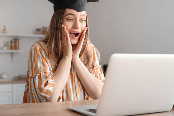 Glückliche Studentin an ihrem Abschlusstag zu Hause. Konzept des Online-Studiums - Foto, Bild