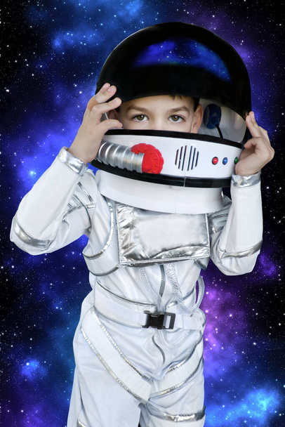 jong jongen kind in een astronaut kostuum met melkweg achtergrond - Foto, afbeelding