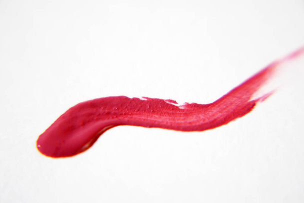 Flüssiger Lippenstift auf weißem Hintergrund, roter flüssiger Lippenstift mit einfarbigem Streichen, Nahaufnahme - Foto, Bild