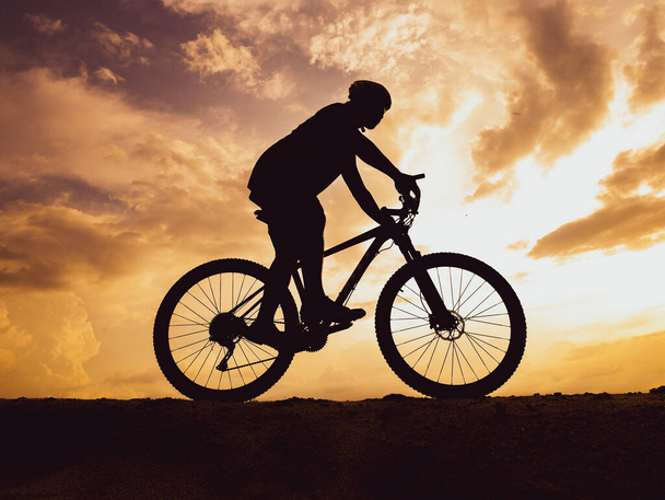Βουνό ποδήλατο σιλουέτα κατάρτισης στα ψηλά βουνά το βράδυ, όμορφα χρώματα. - Φωτογραφία, εικόνα