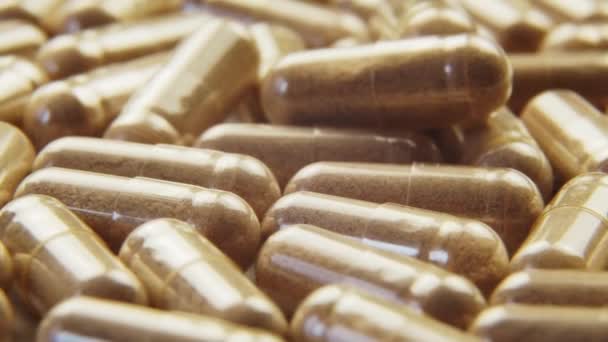 Pilules capsules avec des additifs biologiques rotation macro shot - Séquence, vidéo