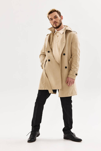 άνδρας σε μπεζ παλτό μόδας θέτοντας μοντέρνα τάση στυλ - Φωτογραφία, εικόνα