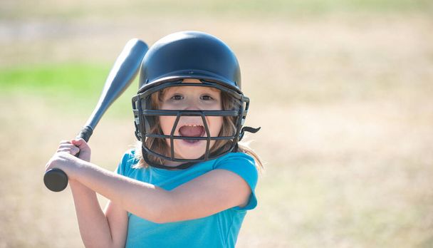 Portrait of excited kid baseball player wearing helmet and hold baseball bat. - Foto, imagen