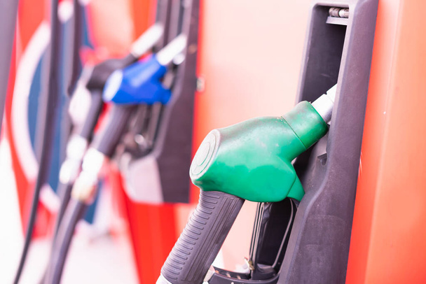 Nahaufnahme grüner Treibstoffdüse am Tank einer Tankstelle in einer kommerziellen Tankstelle zum Füllen von Energie aus Öl in das Auto für den Transport ohne Kopierraum im Rahmen. - Foto, Bild