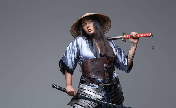 Attractive eastern woman warrior with katana and hat - Photo, Image