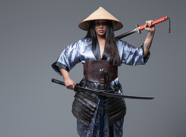 Ασιάτισσα πολεμίστρια με κάσα και σπαθιά σαμουράι - Φωτογραφία, εικόνα