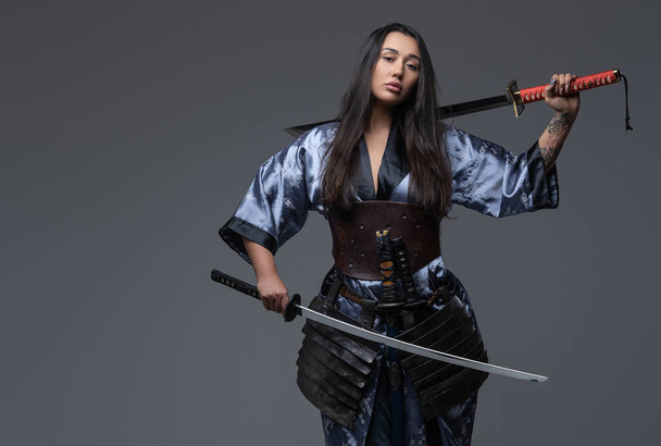 Опасная женщина-самурай позирует с самурайскими мечами - Фото, изображение