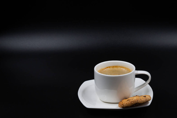 Beyaz kahve kupası, bisküvi ve siyah arka planda kahve. - Fotoğraf, Görsel