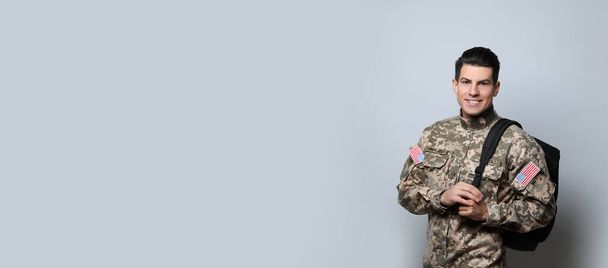 Cadet with backpack on light grey background. Military education - Photo, Image