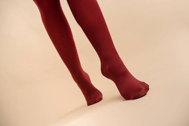 Female legs in the red stockings on a light background in the fitting room. - Valokuva, kuva