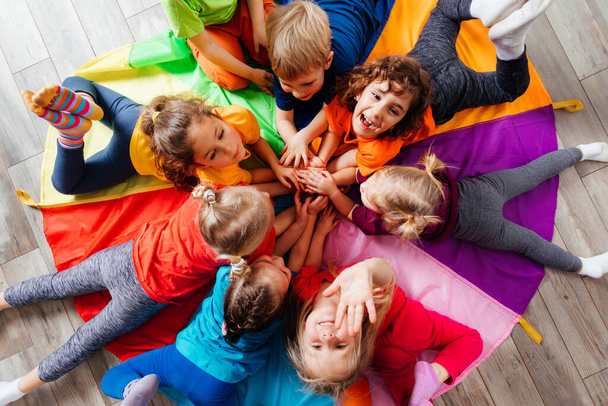 Cheerful children playing team building games on a floor - Photo, image
