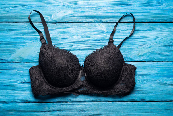Black bra on the blue flat lay shop counter background. - Foto, afbeelding