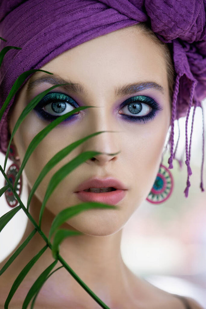 Beautiful young woman with fashion makeup   and turban with leaf. Portrait of beauty fashion model with professional make up and long eyelashes. Beauty and skincare. - Foto, immagini
