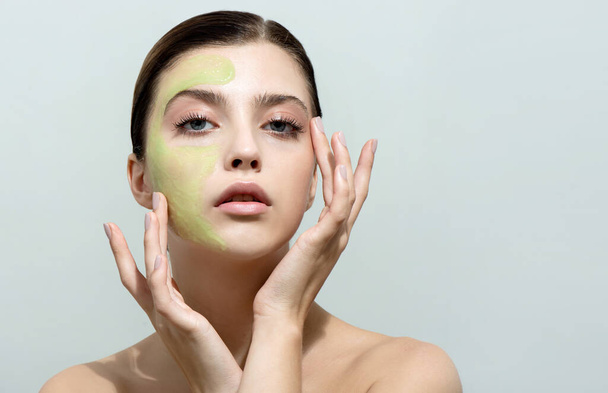 Young woman applying facial gel, peeling or mask on her face. Beauty model with perfect fresh skin and long eyelashes cares about her skin at home. Spa and Wellness, Skin Care Concept. - Fotó, kép