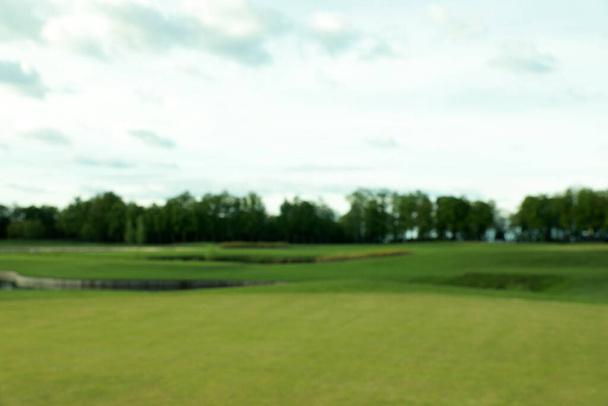 Blurred view of golf course on sunny day - Foto, imagen
