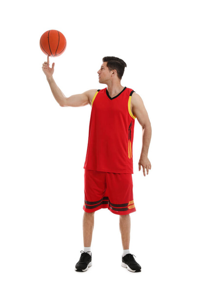 Basketball player spinning ball on finger against white background - Foto, afbeelding