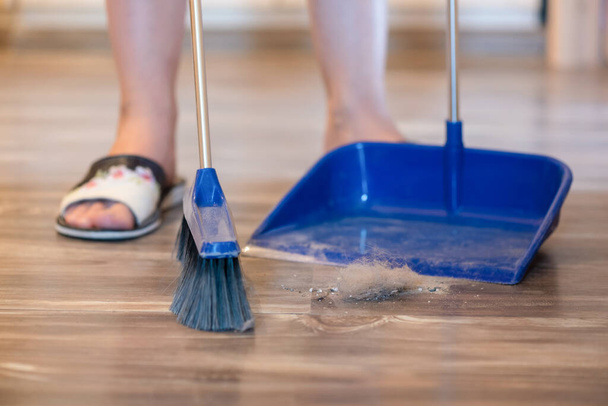 Broom brush and dustpan on the floor. Home cleaning. - Photo, image