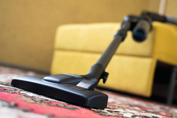 Vacuum cleaner on the carpet in the living room. - Foto, afbeelding