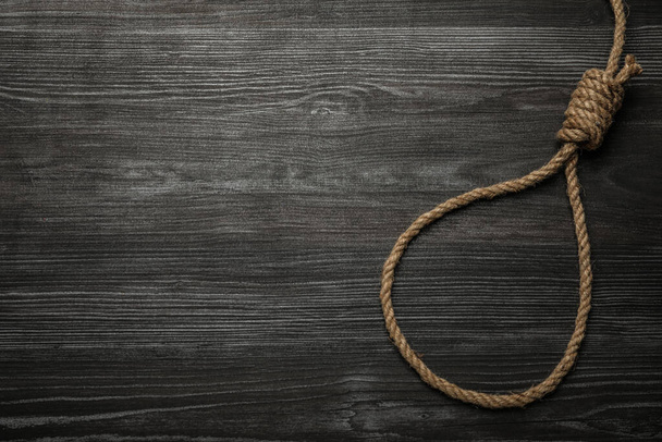 Rope noose on black wooden table, top view. Space for text - Foto, Bild