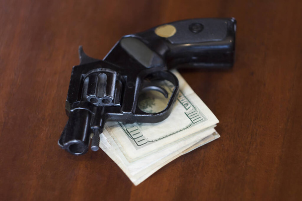 Revolver mit Geldbeutel liegen auf Holztisch - Foto, Bild