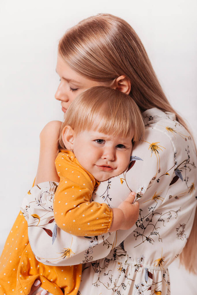 Молодая красивая мама нежно обнимает свою маленькую дочь. Вертикаль - Фото, изображение