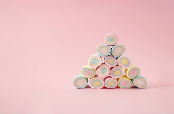 Sweet creative pyramid of pastel colorful marshmallows. Tasty food concept on pink background. - Photo, Image