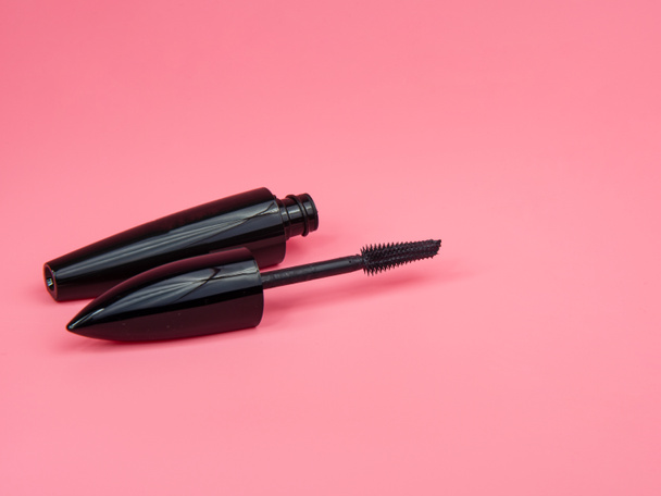 Black tube mascara for lashes make up on pink background - Foto, afbeelding