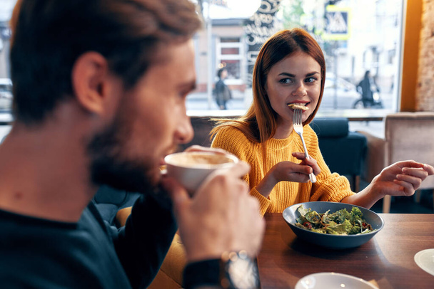 hombres y mujeres emocionales en una mesa en un café divertido pareja casada comida ensalada - Foto, Imagen