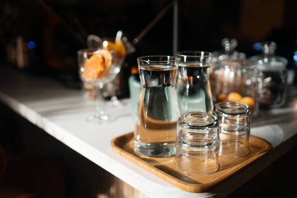 Four glass cups on the bar counter with serving accessories. - Foto, imagen