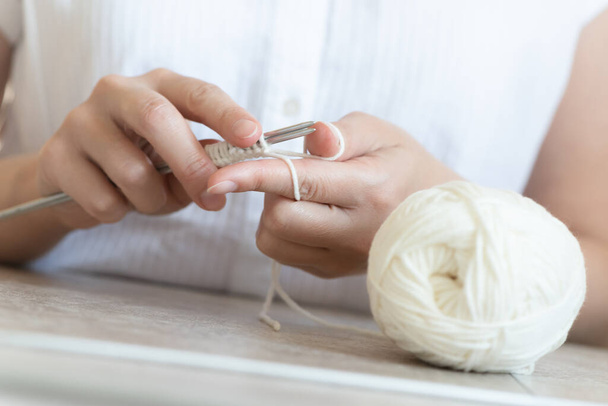 Une femme tricote avec l'aiguille à tricoter en gros plan. - Photo, image