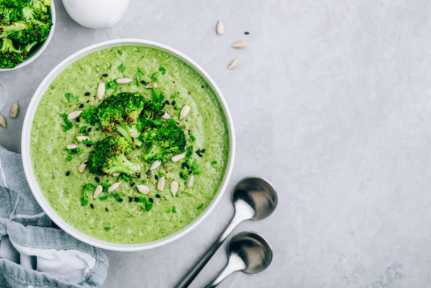 Brokkoli krémleves napraforgóval és szezámmaggal. Zöld vegetáriánus nyári leves, felülnézet. - Fotó, kép