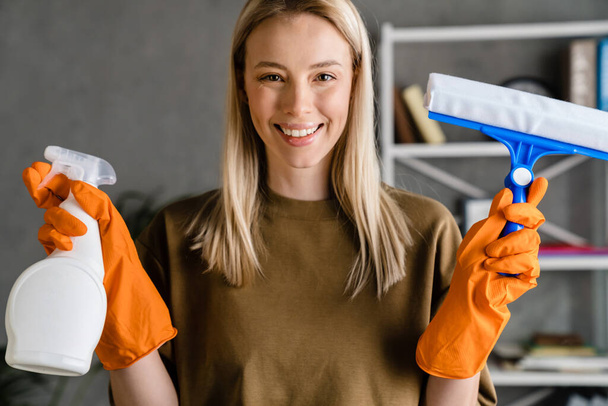 Happy european woman posing with streak and cleaning spray at home - Photo, image