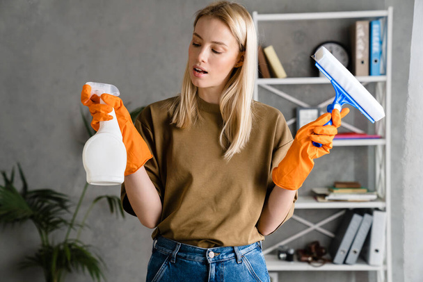 Young european woman posing with streak and cleaning spray at home - Foto, imagen