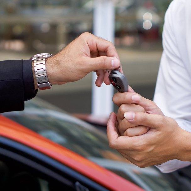 A businessman in black suit  handling car key to the valet service staff. Close up - Photo, Image