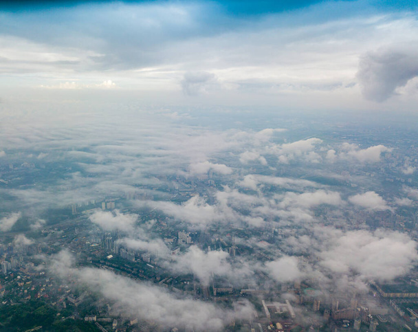 Alto vuelo sobre las nubes en Kiev. Mañana nublada de primavera. Vista aérea alta. - Foto, imagen