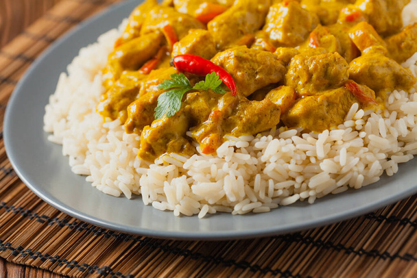 Chicken Curry Sauce. Served with rice. Front view. Natural wooden background. - Fotografie, Obrázek