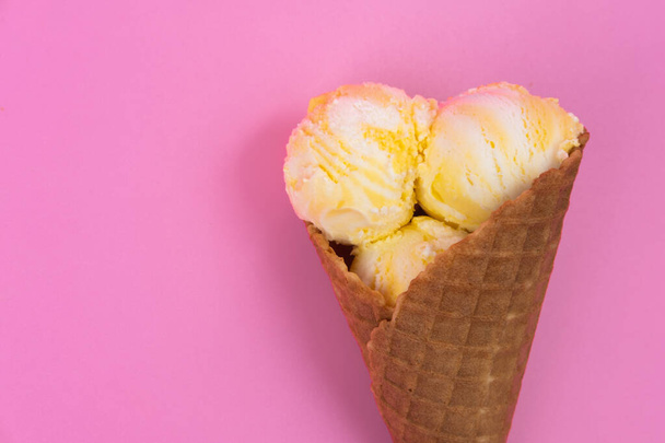 Fruit-scented ice cream balls in a waffle cone on a pink background - Fotografie, Obrázek