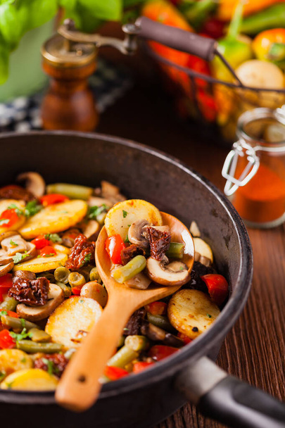 Fried pan vegetables, with mushrooms and dried tomatoes. Seasoned with a mix of herbs - Foto, Imagen
