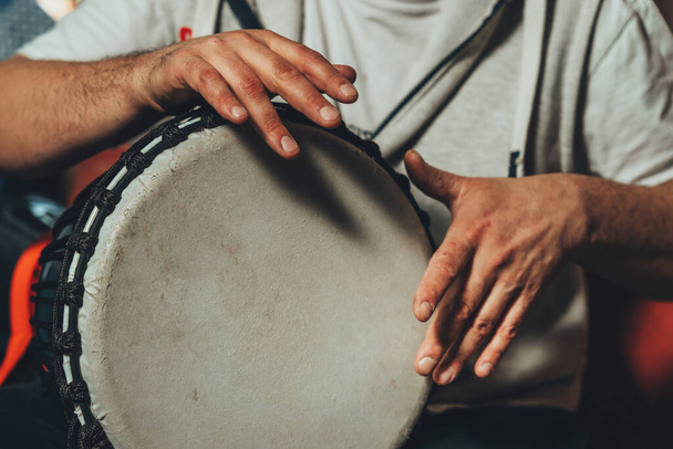 The drummer plays the ethnic percussion musical instrument djembe. - Photo, Image