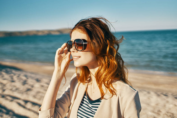 atraktivní žena v slunečních brýlích na písku u moře v horách - Fotografie, Obrázek