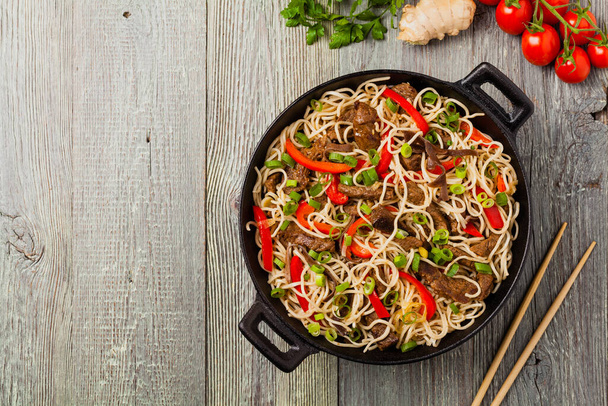 Chinese pasta with beef. Prepared in wok. Wooden background. Top view. - Foto, Imagen