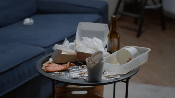 Κοντινό πλάνο του περισσευούμενου φαγητού στο τραπέζι σε άδειο βρώμικο σαλόνι - Πλάνα, βίντεο