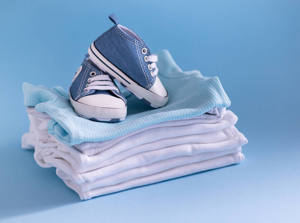 lähikuva vauvanvaatteista ja asusteista sinisellä taustalla - Valokuva, kuva