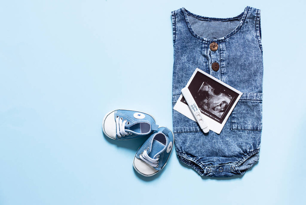 felső nézet a baba ruhák és kiegészítők kék háttér - Fotó, kép