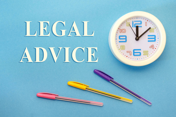 Юридические консультации - буквы на синем фоне, часы и ручки - Фото, изображение