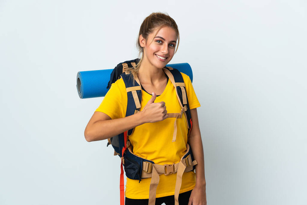 Mladý horolezec žena s velkým batohem izolované na bílém pozadí dává palce nahoru gesto - Fotografie, Obrázek