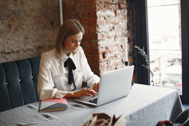 Businesswoman sitting at the table with a laptop - Foto, Imagem