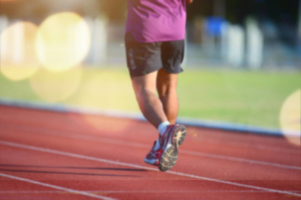 Lente borrosa de un corredor entrenando en una pista. entrenamiento de corredor masculino - Foto, Imagen